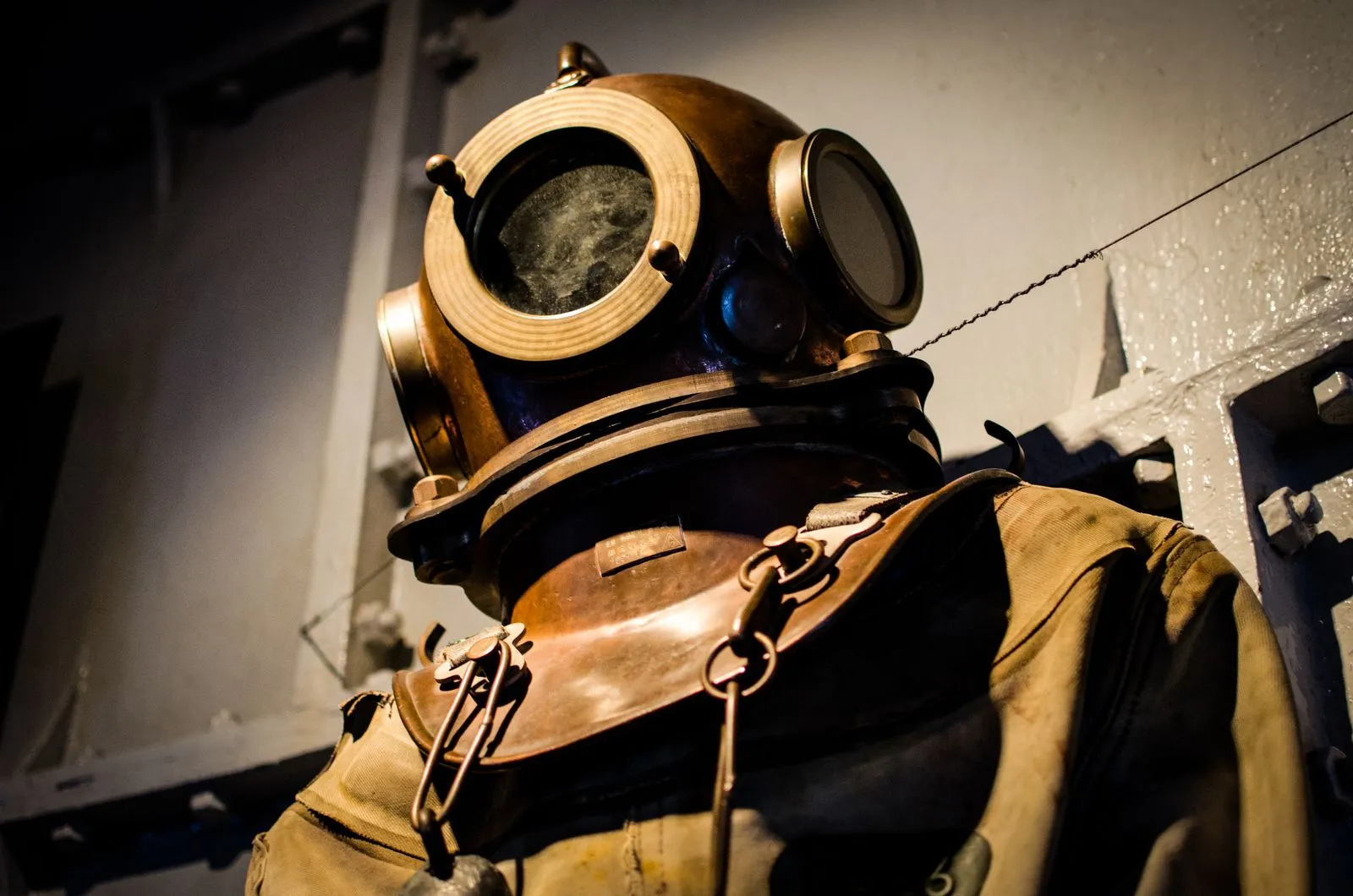 A vintage diving suit displayed in a museum, reflecting historical maritime exploration.